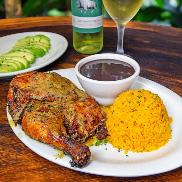Rumba Cuban Cafe's roasted chicken with yellow rice, black beans, avocado, and white wine.