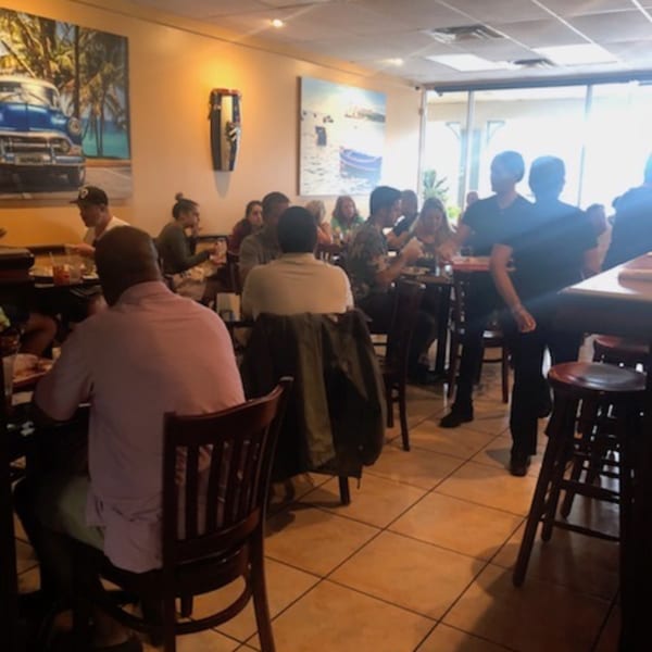 Diners enjoying meals at Rumba Cuban Cafe, with Cuban-themed art on the walls.